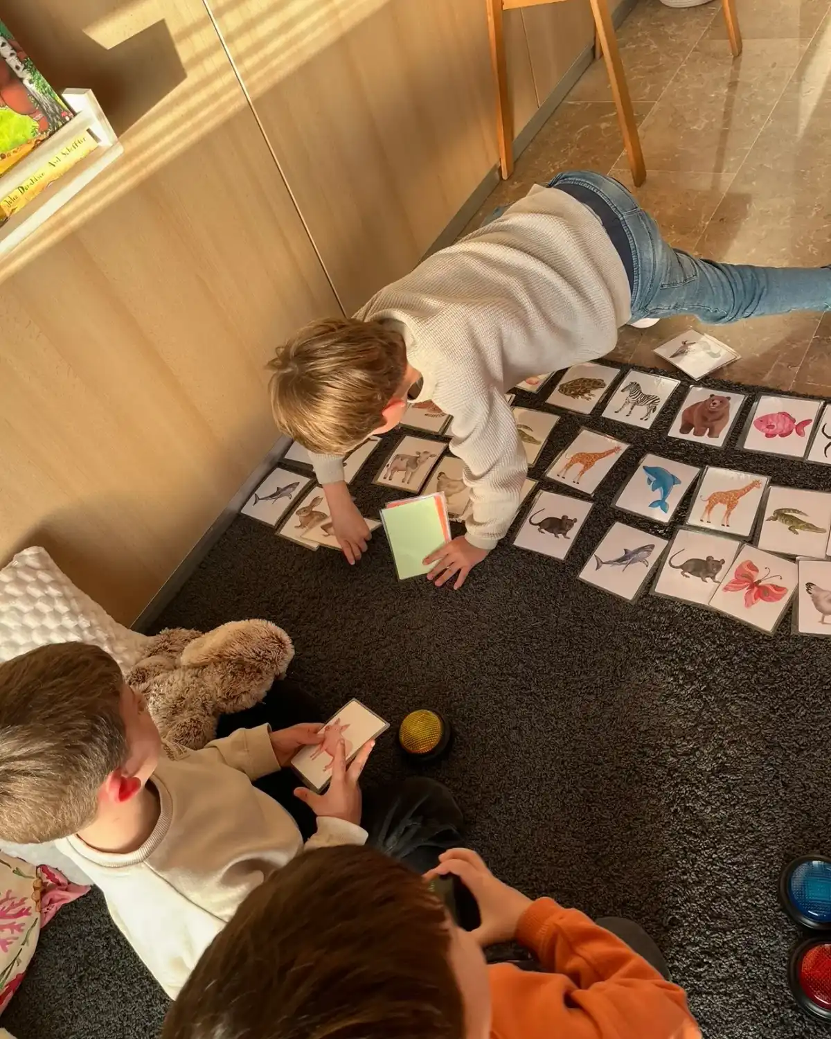 Un niño coloca tarjetas de animales en el suelo durante un juego de vocabulario
